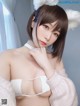 A woman in a white bra and bunny ears posing for the camera.