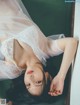 A woman laying on the floor in a white lingerie.