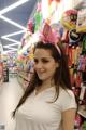 A woman in a white shirt is standing in a store.