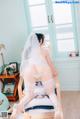 A woman in a white lingerie sitting on a chair.