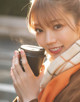 A woman holding a cup of coffee in her hand.