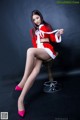 A woman in a red and white outfit sitting on a chair.