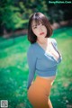 A woman in a blue top and orange pants posing for a picture.