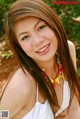 A woman with long brown hair wearing a colorful necklace.