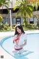 A woman in a nurse outfit sitting in a swimming pool.