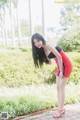 A woman in a red and black dress posing for a picture.