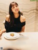 A woman sitting at a table with a plate of food.