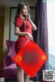 A woman in a red cheongsam holding a red envelope.